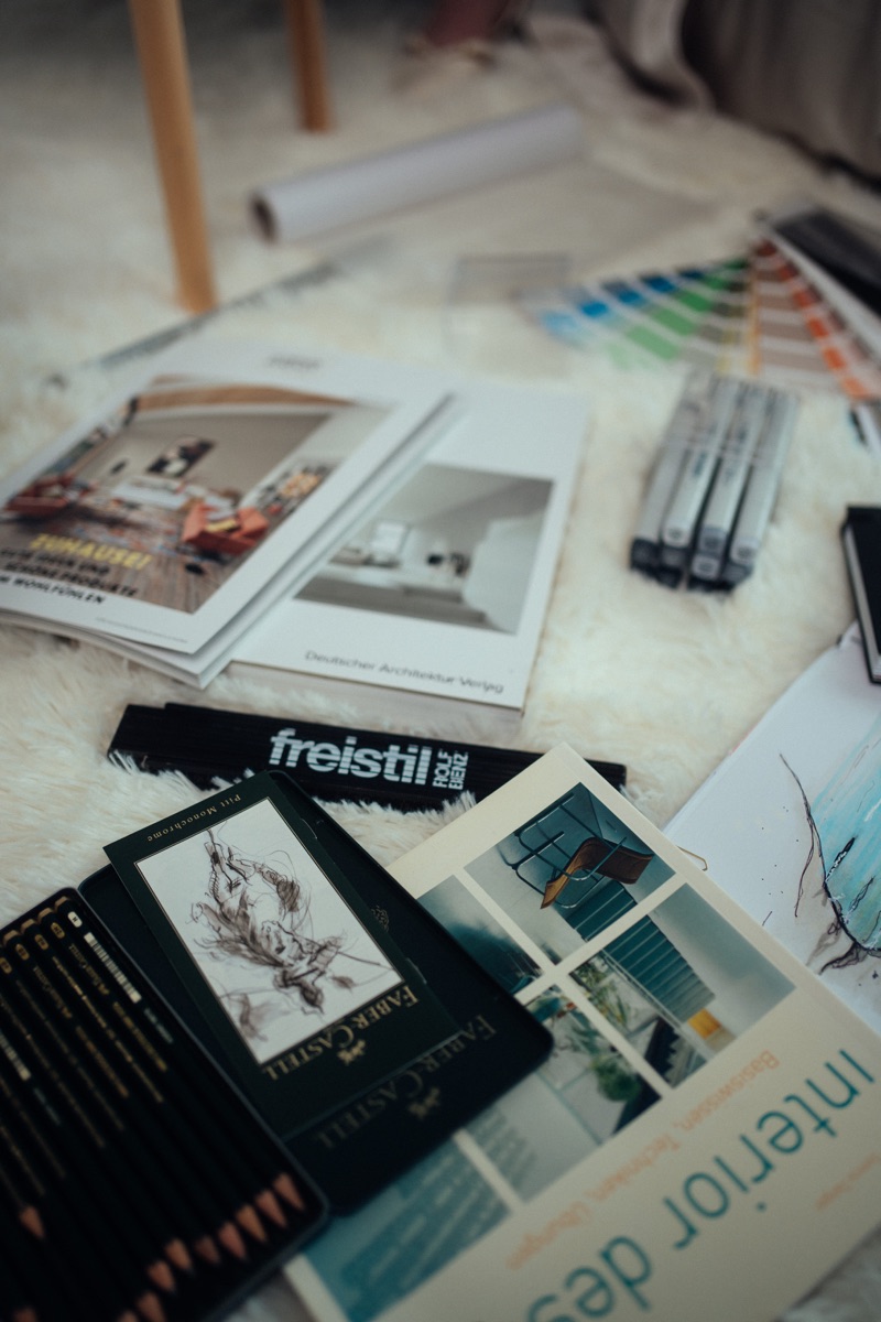 Materialien, Farbmuster und Skizzen auf einer Arbeitsfläche.